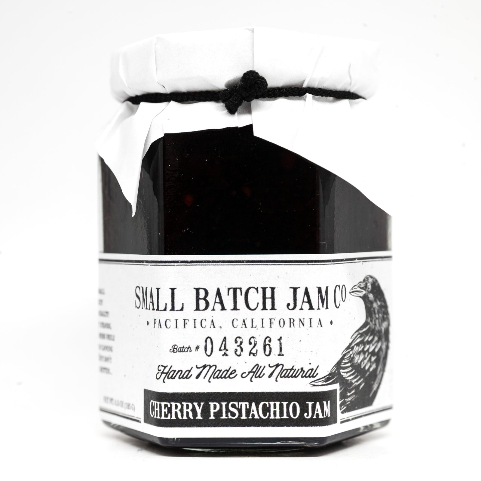 Jar of cherry pistachio jam from Small Batch Jam Co. on a white background