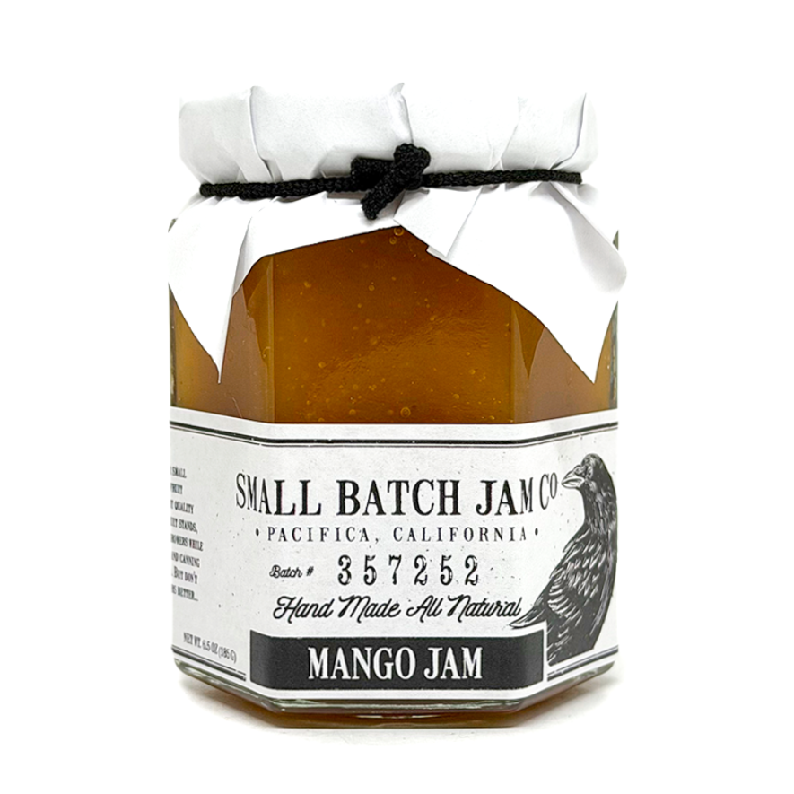 Jar of mango jam with a white label on a white background